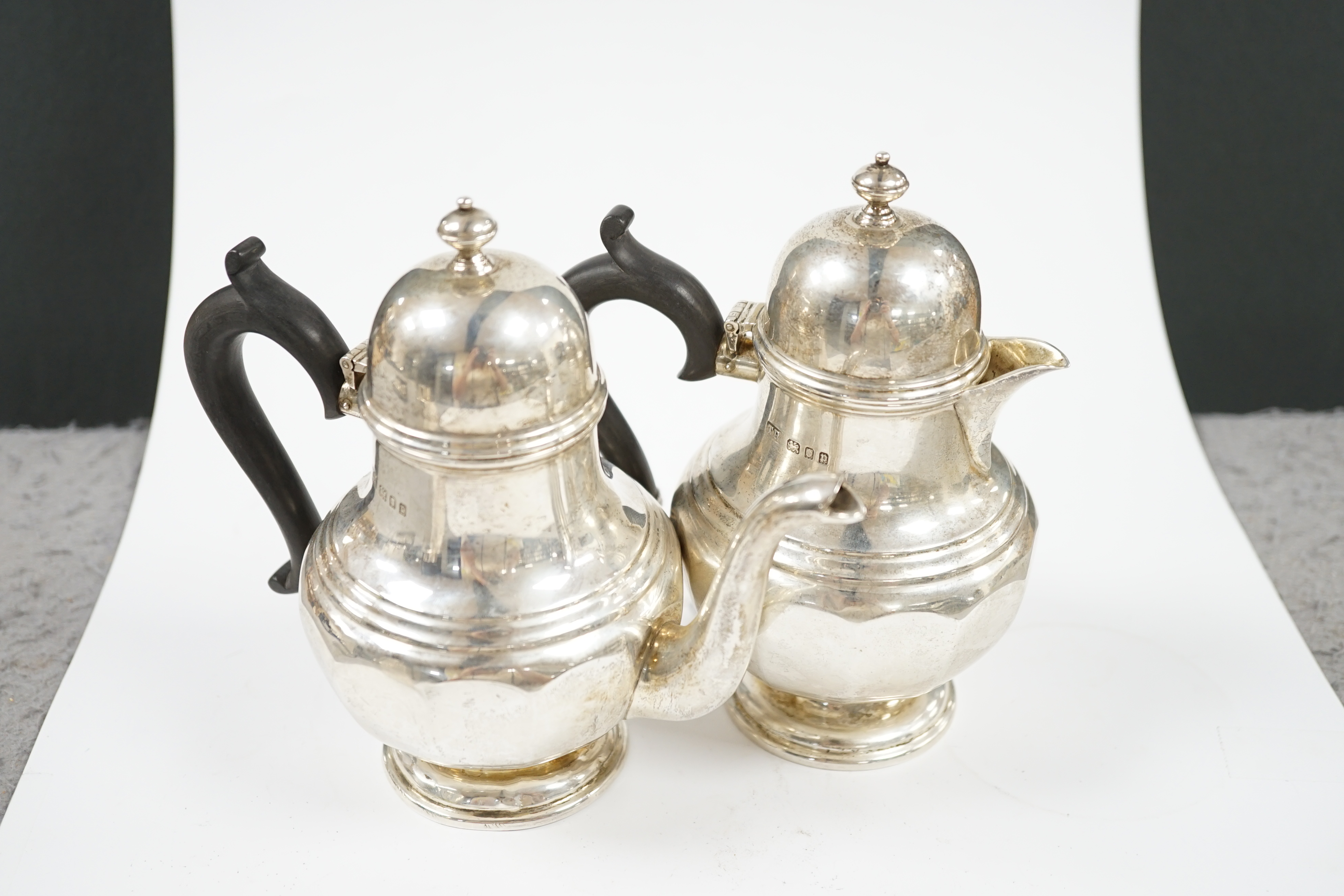 A George V silver bachelors pear shaped café au lait pair, by Theodore Rossi, London, 1930 and an earlier silver tea caddy, gross weight 18.5oz. Condition - poor to fair